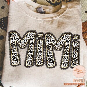 May include: A beige sweatshirt with the word "MIMI" in large, bold letters. The letters are filled with a leopard print pattern and outlined with black lace. The design includes a small pink logo and the text "PNG FILE HANDCRAFTED DESIGN".