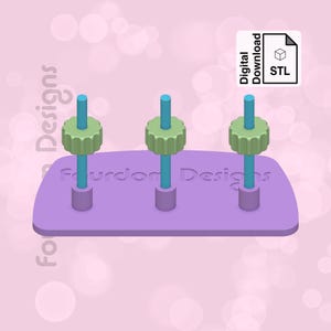 Puede incluir: Una base de impresión 3D de color morado con tres pomos de color verde azulado y verde. La base tiene el texto "Fourdon Designs" impreso en ella. La imagen está etiquetada como "Descarga digital STL".