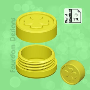 May include: A yellow 3D printed container with a four-leaf clover design on the lid. The container is open and the lid is sitting next to it. The container is made for storing small items.