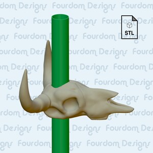 K&ouml;nnte beinhalten: Ein 3D-gedruckter Stier Sch&auml;del mit einem gr&uuml;nen Rohr, das durch die Oberseite des Sch&auml;dels verl&auml;uft. Der Sch&auml;del ist hellbeige und das Rohr ist leuchtend gr&uuml;n. Das Bild ist mit dem Dateityp "STL" gekennzeichnet.