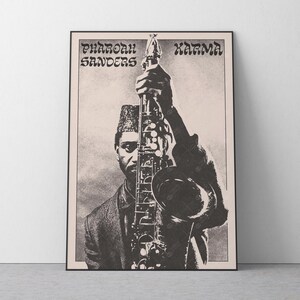 May include: Black and white poster featuring Pharoah Sanders holding a saxophone. The poster has the words "Pharoah Sanders" and "Karma" in a stylized font. The image is a portrait of a man wearing a fez and a jacket.