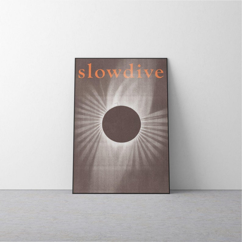 Puede incluir: Un cuadro enmarcado con la palabra "slowdive" en naranja sobre un c&iacute;rculo marr&oacute;n con rayos de luz. La obra de arte tiene una apariencia texturizada y est&aacute; colocada contra una pared blanca.