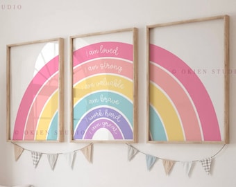 May include: Three framed rainbow prints with positive affirmations, including "I am loved", "I am strong", "I am valuable", "I am brave", "I work hard", and "I am great". The prints are hung on a white wall above a wooden bench with storage bins.