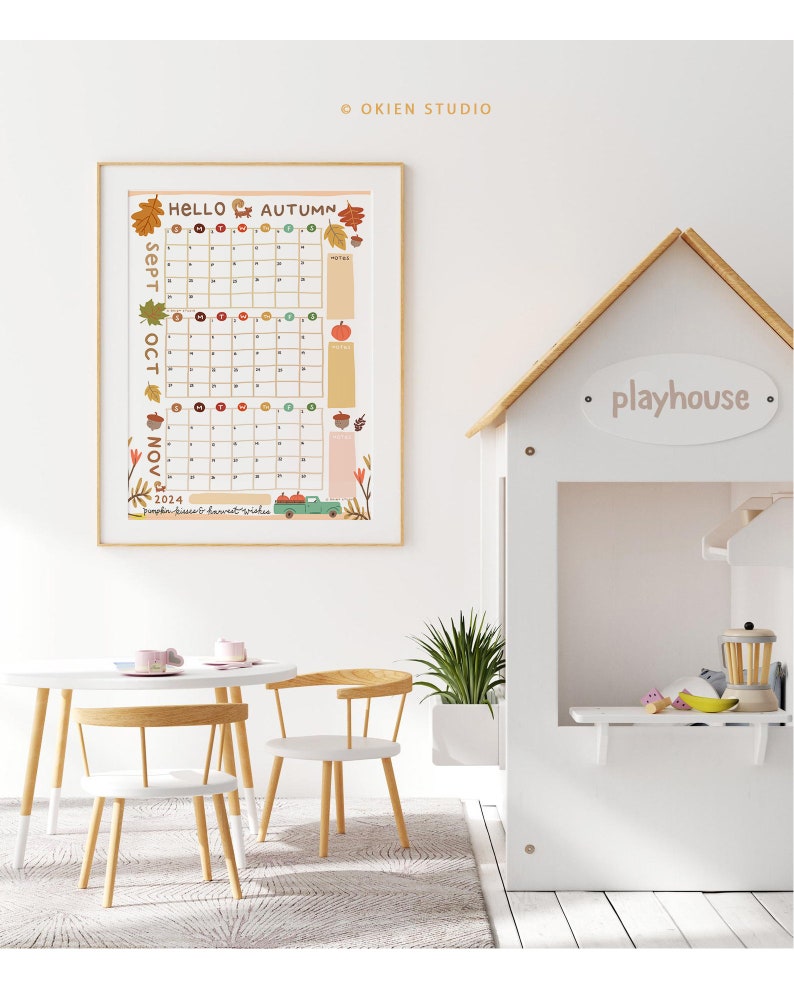 Puede incluir: Una casa de juegos blanca con un letrero que dice "playhouse" y una mesa peque&ntilde;a y sillas delante. Hay un calendario en la pared detr&aacute;s de la casa de juegos con las palabras "Hello Autumn" y los meses de septiembre, octubre y noviembre.
