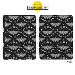 May include: Black iPad case with a white pattern of moths, leaves, and geometric shapes. The case has a black border and a white edge.