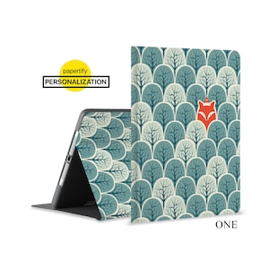 May include: A blue and green patterned iPad case with a fox peeking out from behind the trees. The case has a stand feature and the text "ONE" is printed on the bottom right corner.