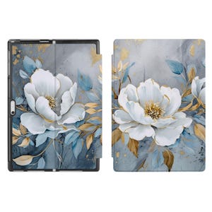 Könnte beinhalten: Eine Tablethülle mit floralem Design. Die Hülle ist aus weichem, strapazierfähigem Material gefertigt und zeigt eine wunderschöne Aquarellmalerei von weißen Blumen mit goldenen Akzenten auf blauem Hintergrund.