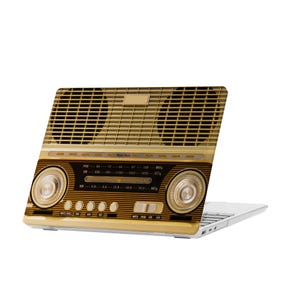 May include: A gold and black laptop skin with a vintage radio design. The skin features a dial with the text "Music Box" and "FM", "AM", "CD", "MP3", "USB", and "AUX" buttons.