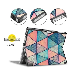 May include: A black case with a colourful geometric pattern featuring mandala designs. The case is designed for a Microsoft Surface tablet and has a built-in kickstand.