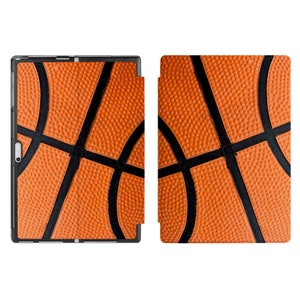 Könnte beinhalten: Eine schwarze Hülle mit einem Basketballmuster. Die Hülle hat eine strukturierte Oberfläche und ist zum Schutz eines Tablets oder Telefons konzipiert.