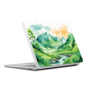 May include: A white laptop with a watercolor design of a green mountain range and a river flowing through it. The design is on the back of the laptop.