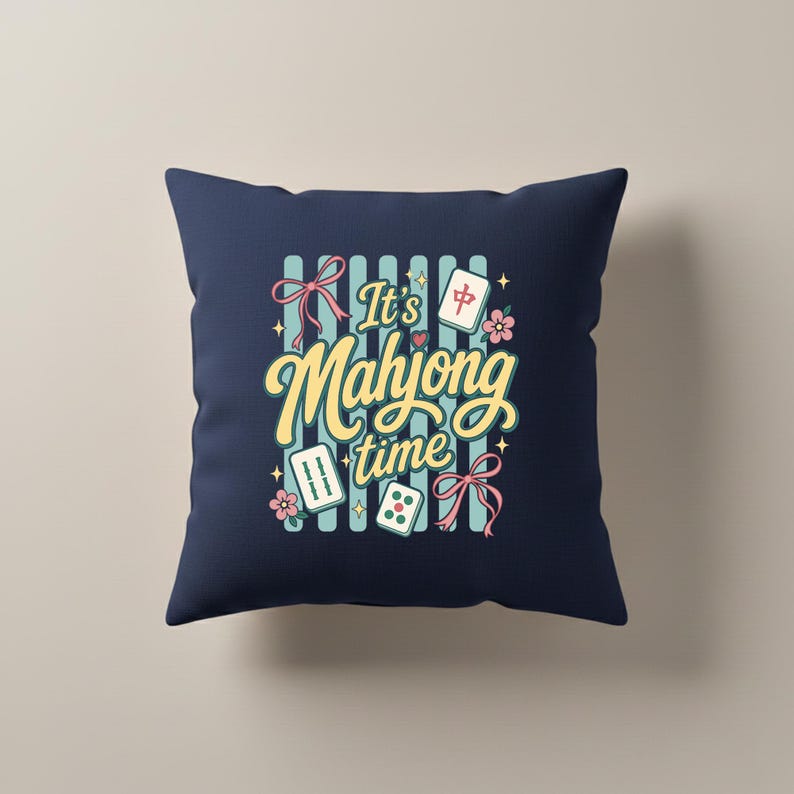 Puede incluir: Coj&iacute;n cuadrado azul marino con el texto "It's Mahjong time" en escritura amarilla. El dise&ntilde;o incluye fichas de Mahjong, dados, flores y lazos en rosa, turquesa y blanco. El fondo tiene rayas verticales turquesas.