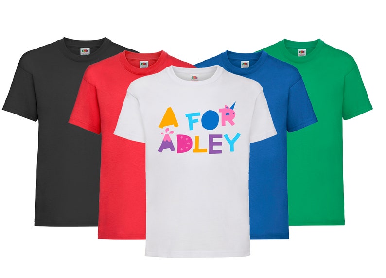 K&ouml;nnte beinhalten: F&uuml;nf T-Shirts in verschiedenen Farben: Schwarz, Rot, Wei&szlig;, Blau und Gr&uuml;n. Das wei&szlig;e T-Shirt hat einen bunten Aufdruck mit der Aufschrift "A for Adley".