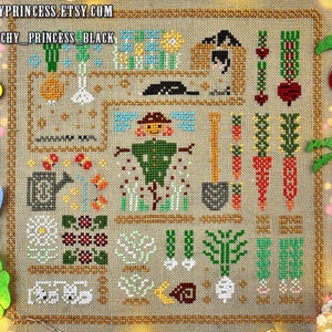 May include: A cross-stitch pattern featuring a whimsical garden scene with a scarecrow, vegetables, flowers, and a watering can. The pattern is on a beige fabric with brown borders.