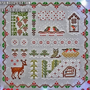 May include: A cross-stitch pattern featuring a winter scene with a deer, birds, a house, and trees. The pattern is on a white background with red and green accents.