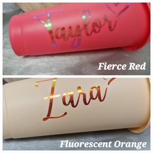 Puede incluir: Dos vasos aislados, uno en rojo intenso y otro en naranja fluorescente. El vaso rojo tiene el nombre "Taylor" en escritura iridiscente, y el vaso naranja tiene el nombre "Zara" en escritura iridiscente. El texto "Fierce Red" y "Fluorescent Orange" est&aacute;n debajo.