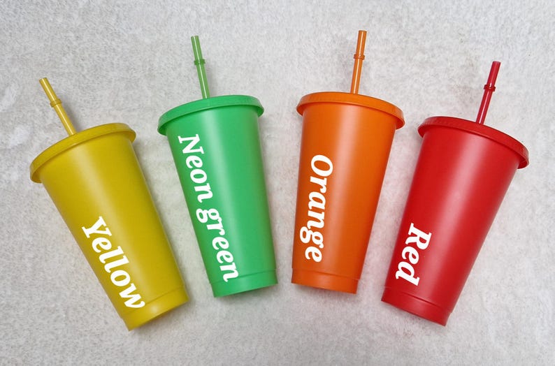 May include: Four reusable tumblers with lids and straws. The tumblers are yellow, neon green, orange, and red. Each tumbler has a white label with the colour name printed on it.