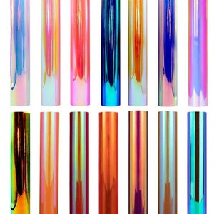 Puede incluir: Una colecci&oacute;n de rollos de vinilo iridiscente en varios colores, incluyendo blanco &oacute;palo, melocot&oacute;n amarillo rosa, rosa intenso, azul pavo real, naranja beige, azul jacinto y p&uacute;rpura atardecer. Colores adicionales incluyen verde malaquita, naranja coral, rojo intenso, naranja fluorescente, p&uacute;rpura orqu&iacute;dea, rosa atardecer y verde bosque.