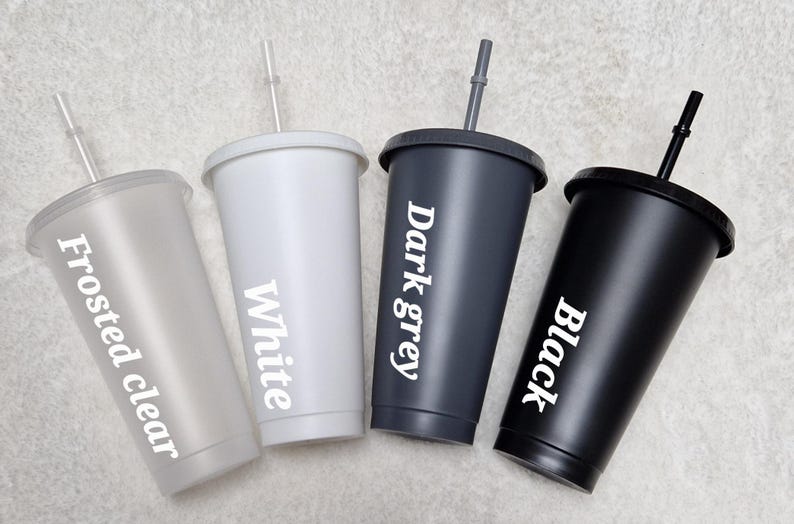 May include: Four reusable tumblers with lids and straws in frosted clear, white, dark grey, and black. Each tumbler has the colour name printed on the side.