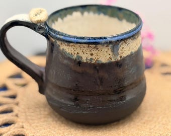 Handgjord kaffemugg Stengodslera, tumstöd. Spräcklig krämbrunblå