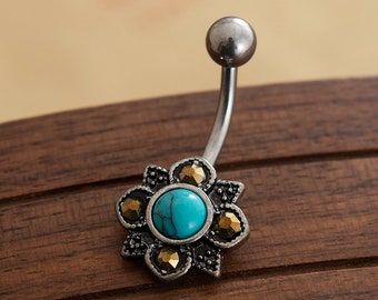 May include: A silver belly button ring with a turquoise stone surrounded by gold-toned accents in a flower design.