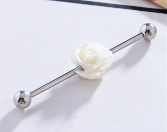 May include: A white rose flower charm on a silver barbell, a type of body jewellery.