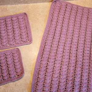 May include: Two purple crocheted pot holders and a larger purple crocheted dishcloth. The dishcloth has a textured pattern.