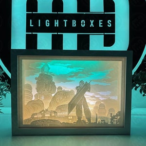 May include: A white light box with a 3D paper cut-out design of a character from the video game Final Fantasy VII. The character is standing in front of a cityscape with a blue sky and clouds. The light box is illuminated from behind, creating a glowing effect.