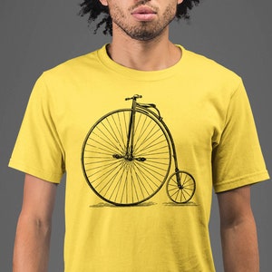 May include: A yellow t-shirt with a black and white illustration of a vintage bicycle with a large front wheel.