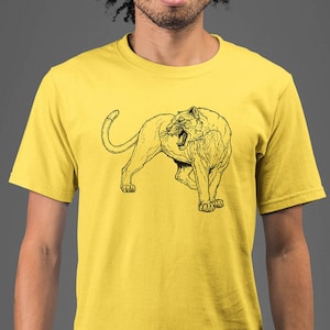 May include: A yellow t-shirt with a black line drawing of a lion on the front.
