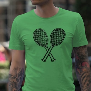 Puede incluir: Una camiseta verde con un gráfico negro de dos raquetas de tenis cruzadas.
