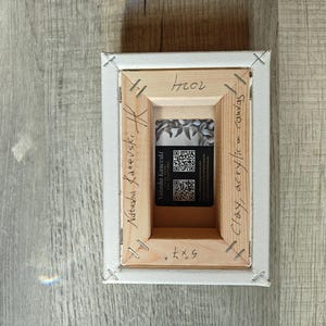 May include: Back of a stretched canvas art piece. The wooden frame is stapled to the canvas. The artist's name, "Natasha Kanevski", is written on the frame. A business card is visible in the center. The canvas measures 5x7 inches.