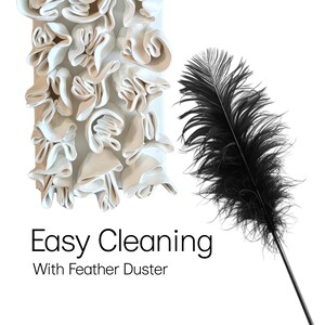 May include: A black feather duster with a long handle is displayed next to a white, textured wall hanging with a ruffled design. The text "Easy Cleaning With Feather Duster" is at the bottom of the image.