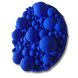 May include: A vibrant, abstract wall art piece featuring a cluster of varying-sized spheres in a deep blue hue. The spheres are densely packed, creating a textured, three-dimensional effect. The artwork is mounted on a circular base.