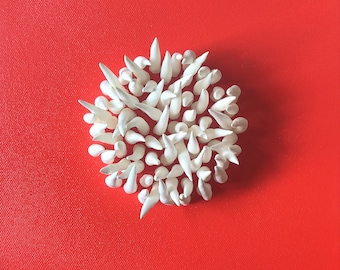 Escultura de pared de arcilla roja y blanca sobre lienzo: arte costero abstracto.