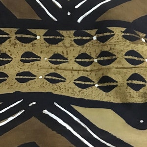 May include: Abstract textile pattern featuring a repeating design in black, brown, and tan. The pattern includes geometric shapes, lines, and stylized leaf-like forms, with white accents. The fabric has a textured appearance.
