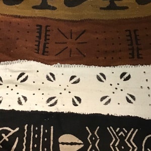 May include: A close-up of a woven fabric with a repeating pattern of black and white geometric shapes. The fabric is made of a natural material and has a rough texture.