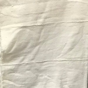 Peut inclure: Tissu blanc avec une texture tissée et des coutures horizontales.