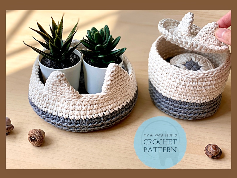 May include: Two crocheted baskets with lids, one with a gray and white color scheme and the other with a gray and white color scheme. The baskets are filled with small potted plants. The text "MY ALPACA STUDIO CROCHET PATTERN" is visible in the image.