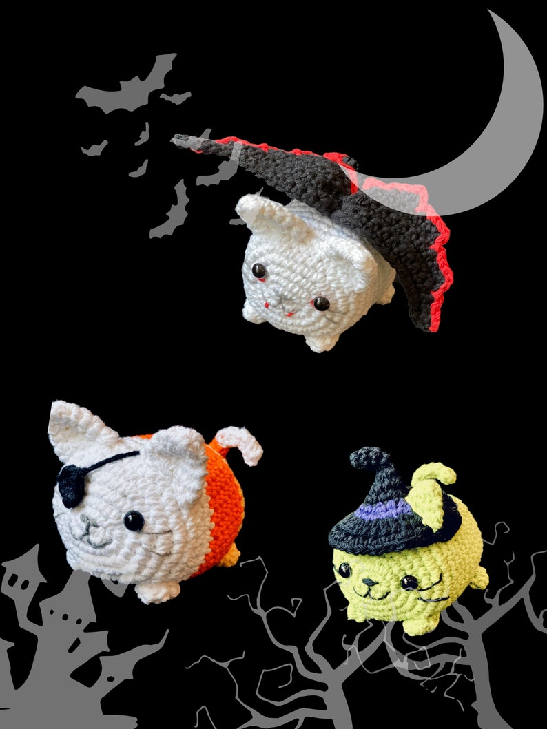 Puede incluir: Tres juguetes de crochet con forma de gato disfrazados para Halloween. Un gato blanco con una capa negra y ribete rojo, un gato blanco con un disfraz de caramelo de ma&iacute;z naranja y blanco, y un gato verde con un sombrero de bruja negro.