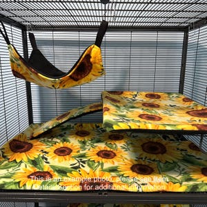 Puede incluir: Un conjunto de accesorios para jaulas de animales peque&ntilde;os con estampado de girasoles sobre fondo crema. Incluye una hamaca colgante con interior negro, una funda para plataforma rectangular y una funda para rampa de tela suave con girasoles.
