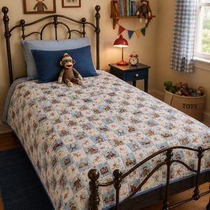 May include: A child's bedroom with a wrought iron bed frame, blue bedding, and a patterned quilt. The quilt features a repeating pattern of sock monkeys and vehicles. Two framed prints with the text "BE SILLY BE KIND" hang above the bed.