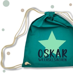 Può includere: Una borsa a cordoncino turchese con una stella verde chiaro e il testo "OSKAR WECHSELSACEN".