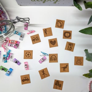 Può includere: Un set di 12 etichette regalo in carta kraft marrone con vari disegni, tra cui un cuore, un pallone da calcio, una fata, un camion, un dinosauro, un arcobaleno, una ballerina, un fungo, un coniglio, un orso, un cavallo e la parola "WILD".