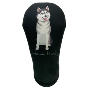 May include: Black golf club head cover featuring a Siberian Husky illustration. The dog is depicted in shades of gray, white, and black, with its tongue sticking out. The words "Siberian Husky" are written in a script font.