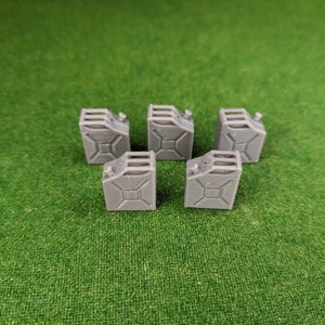 May include: Six grey metal jerrycans, each with a cap on top, are arranged in a row on a green surface.