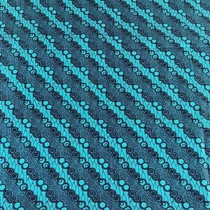 Puede incluir: Tela azul y negra con un patrón repetitivo de círculos y espirales. La tela tiene un patrón de rayas diagonales.