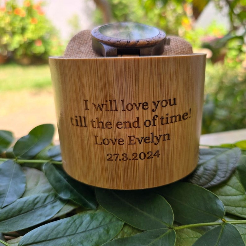 May include: A wooden watch with a brown band is displayed in a bamboo watch box. The box is engraved with the message "I will love you till the end of time! Love Evelyn 27.3.2024".