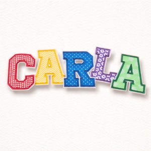 Könnte beinhalten: Bunte Stoffbuchstaben, die den Namen "CARLA" buchstabieren. Die Buchstaben sind in verschiedenen Farben und Mustern gehalten, darunter rote Punkte, gelbe Zickzackmuster, blaue Punkte, lila Blumenmuster und grüne Blumenmuster. Die Buchstaben sind leicht angewinkelt.