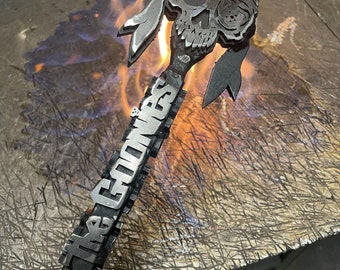 May include: A metal skull with an eye patch and a bandana is attached to a metal rod. The rod is heated with a torch and the text "The Goons" is engraved on the rod.